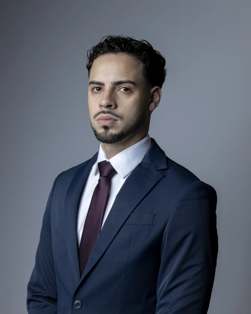 Guilherme Alves Franco, advogado fundador da Alves Franco Advocacia, com terno azul e gravata vinho.